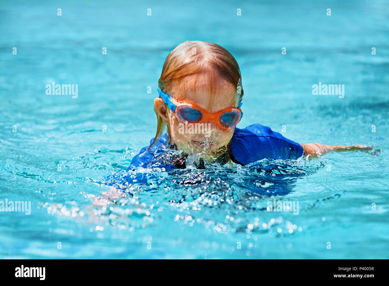 Niño feliz en traje de neopreno y gafas, aprender a nadar, divertirse en la  piscina exterior. Estilo de vida familiar saludable, deportes acuáticos,  actividades para niños, clases de natación Fotografía de stock -