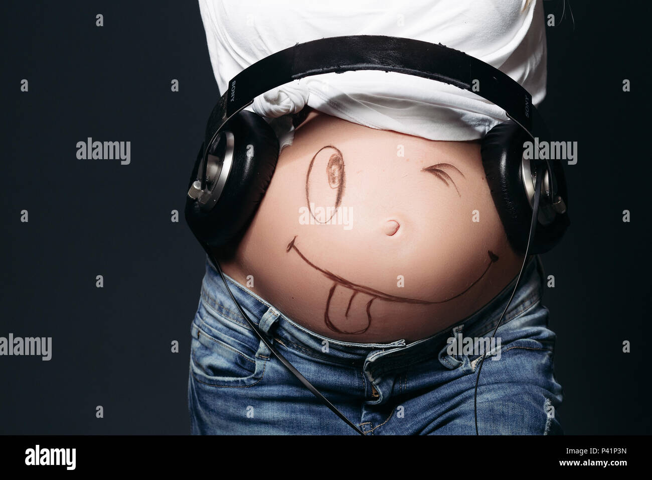 Las mujeres embarazadas con grandes auriculares sobre el estómago  Fotografía de stock - Alamy