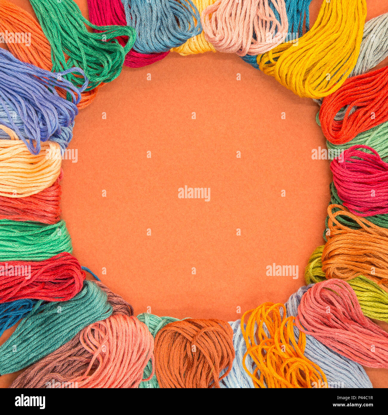Muchas muestras de tejidos de lana sobre un papel con textura de fondo naranja con copia espacio en el medio. Foto de stock