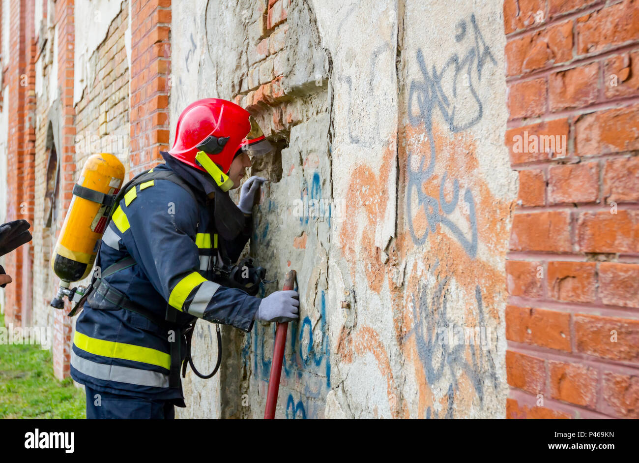 El Bombero Esta Mirando A Traves Del Agujero Que Hizo En Una Pared De Ladrillo Estimar La Situacion Actual Foto Imagen De Stock 209122361 Alamy