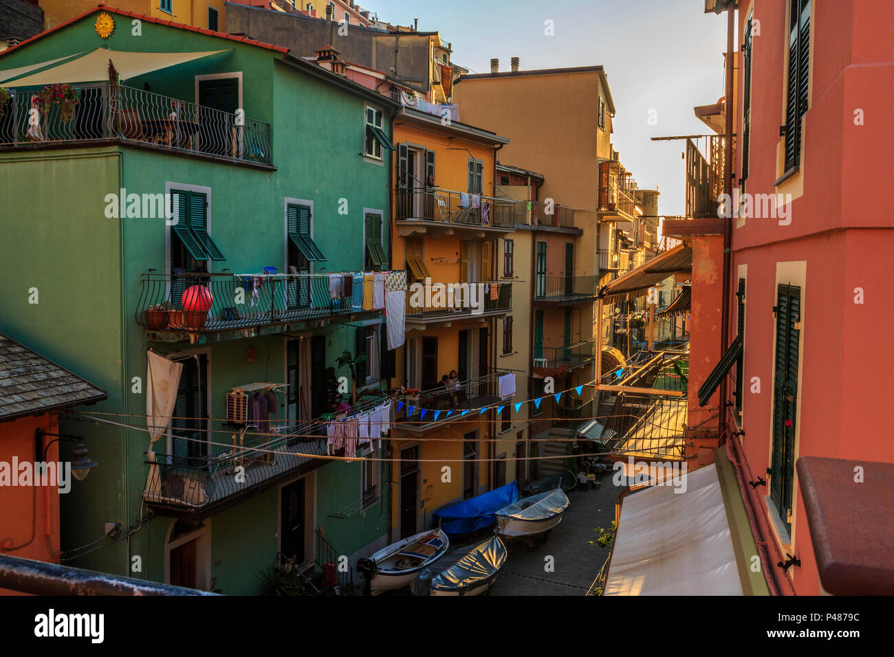 Manarola, Cinque Terre, tranquila tarde escena callejera con coloridas casas y signos de la vida cotidiana. Foto de stock