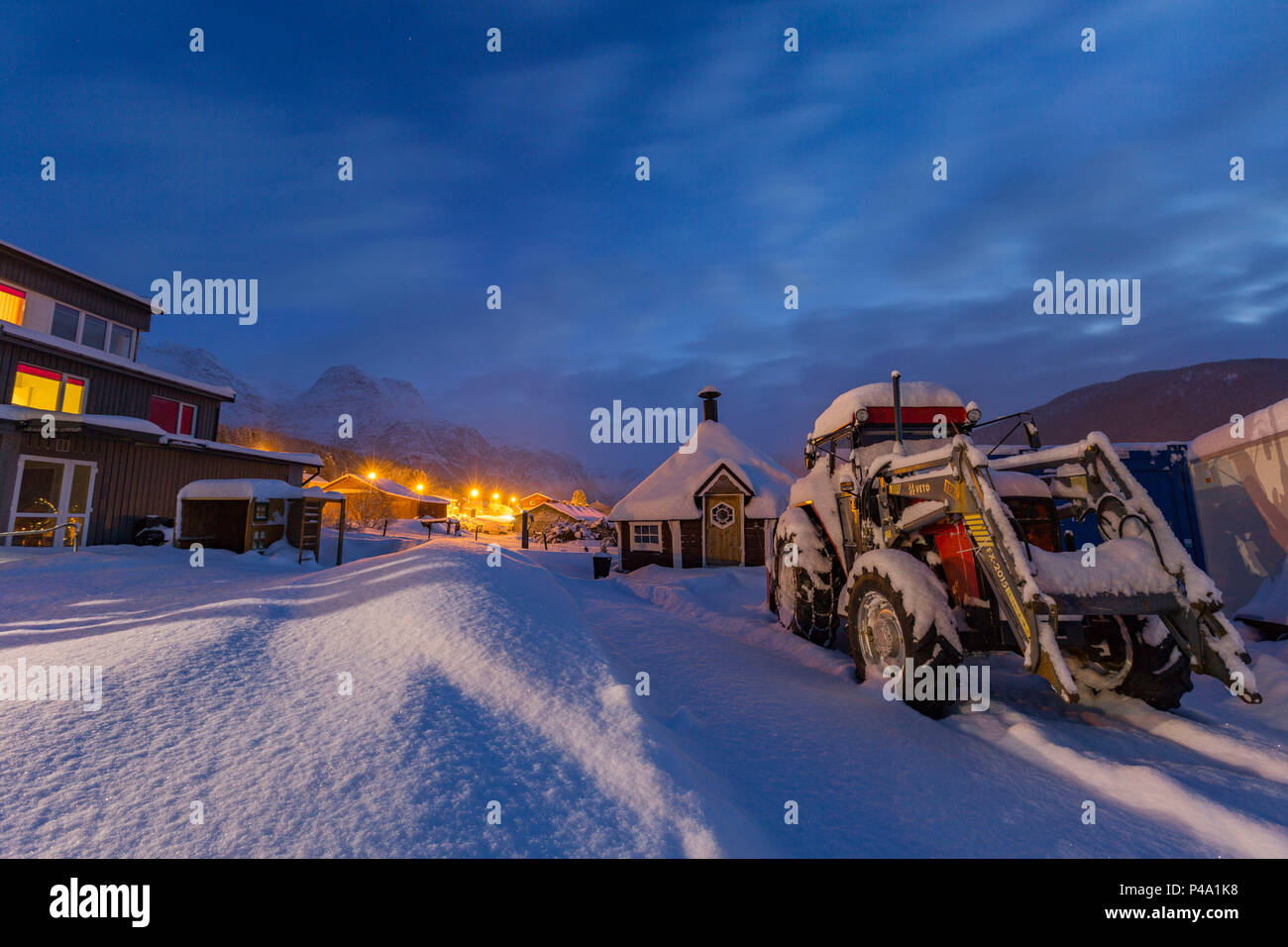 Tractor cubierto por la nieve durante la noche en la aldea, Evenes Bogen, Ofotfjorden, Nordland, Noruega, Europa Foto de stock