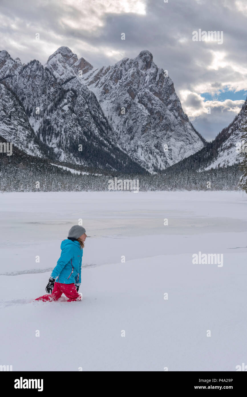 Dobbiaco/Toblach, provincia de Bolzano, Tirol del Sur, Italia. Un niño camina sobre el lago de invierno Foto de stock