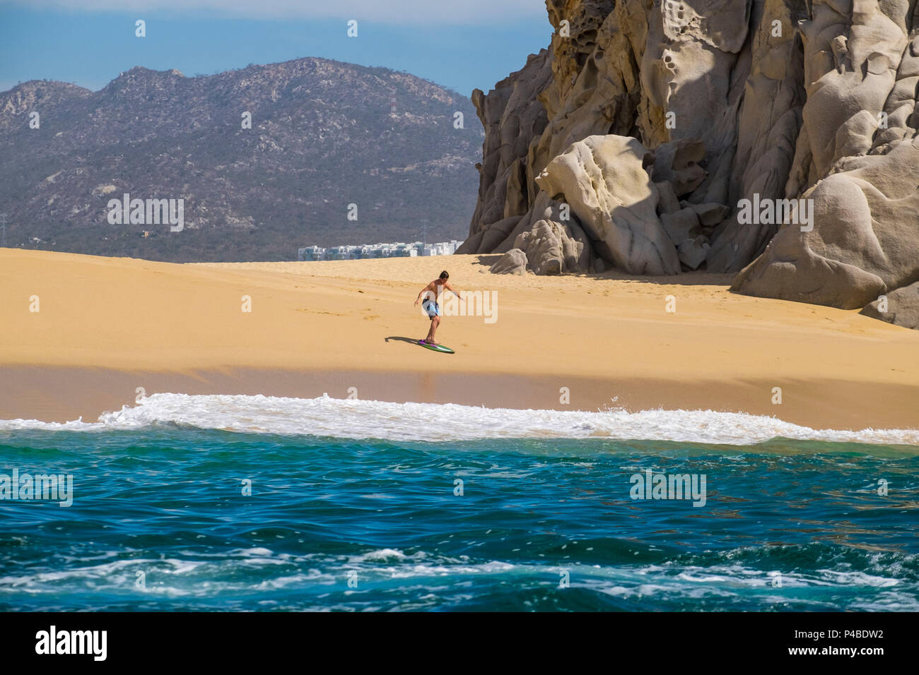 Surfista en la playa del amor y el divorcio en Cabo San Lucas, en el estado de Baja California Sur, en el norte de México Foto de stock