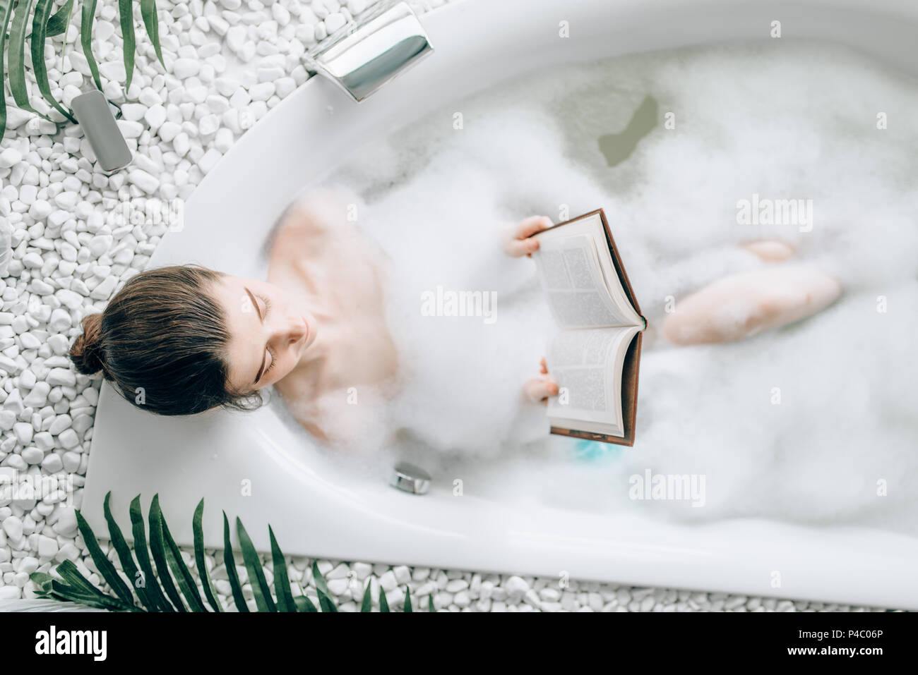 Mujer acostado en la bañera con espuma y lee magazine Fotografía de stock -  Alamy