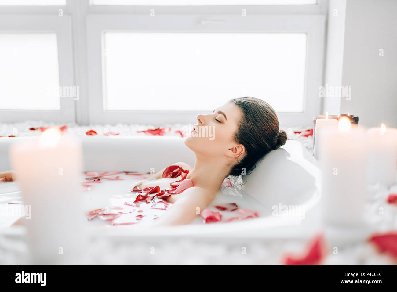 Mujer duerme en la bañera con pétalos de rosa, espuma Fotografía de stock -  Alamy