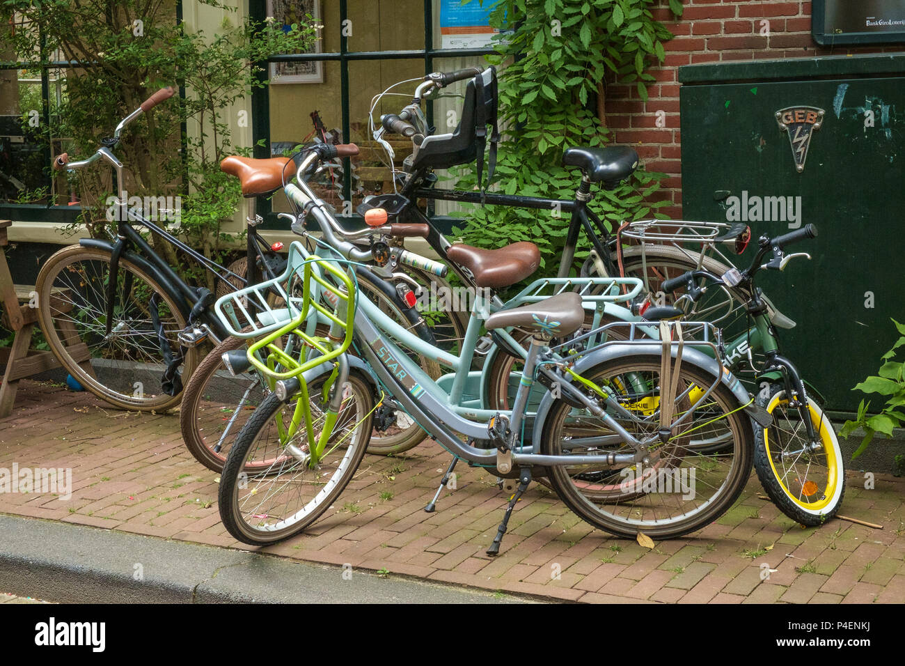Una familia de bicicletas aparcada en una acera en Amsterdam. Foto de stock