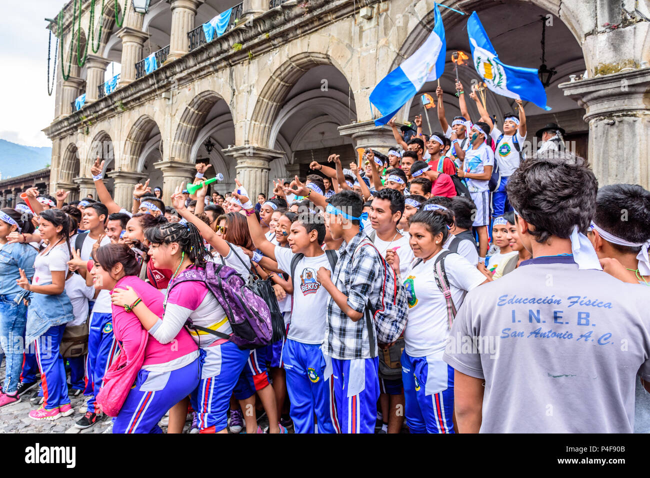 Antigua, Guatemala - 14 de septiembre de 2015: Estudiantes agitar banderas y antorchas encendidas y posar para fotos fuera del ayuntamiento en el día de la Independencia de Guatemala Foto de stock