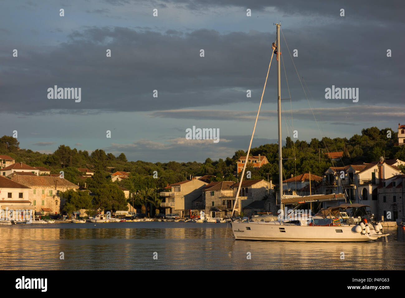 Un fotógrafo en la cima del mástil de un barco, mientras que en el ancla, en Croacia Foto de stock