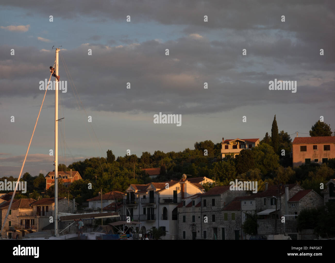 Un fotógrafo en la cima del mástil de un barco, mientras que en el ancla, en Croacia Foto de stock