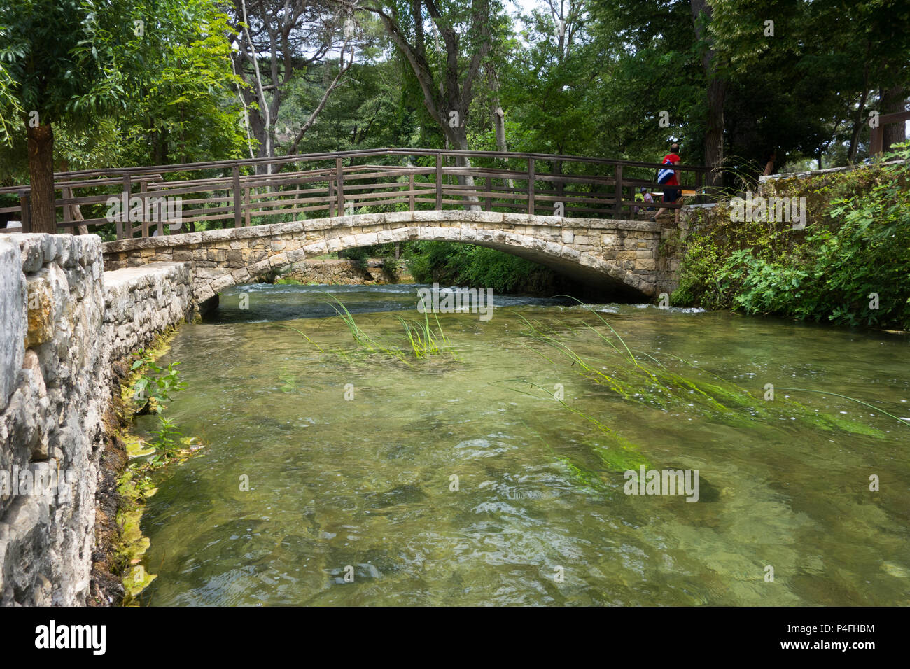 Vista de un pequeño río que pasa bajo un puente en el Parque Nacional de Krka, Croacia Foto de stock