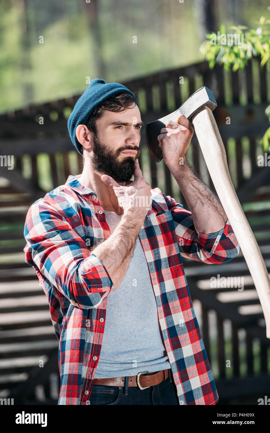 Leñador en camisa a afeitarse la barba el hacha al aserradero Fotografía de stock - Alamy