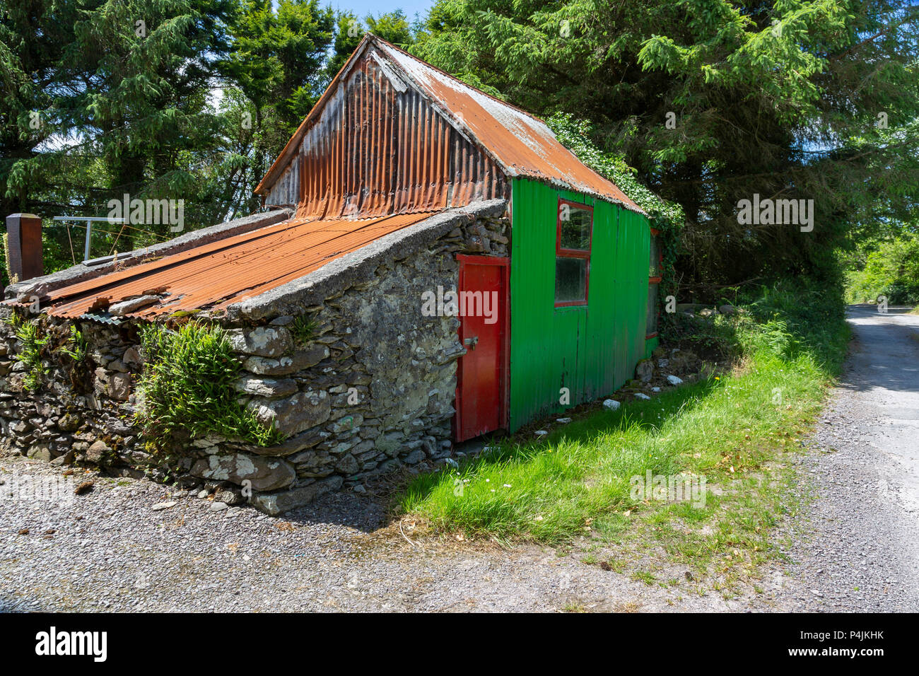 Pequeño edificio de piedra y metal corrugado en un carril del país en el condado de Kerry, Irlanda Foto de stock