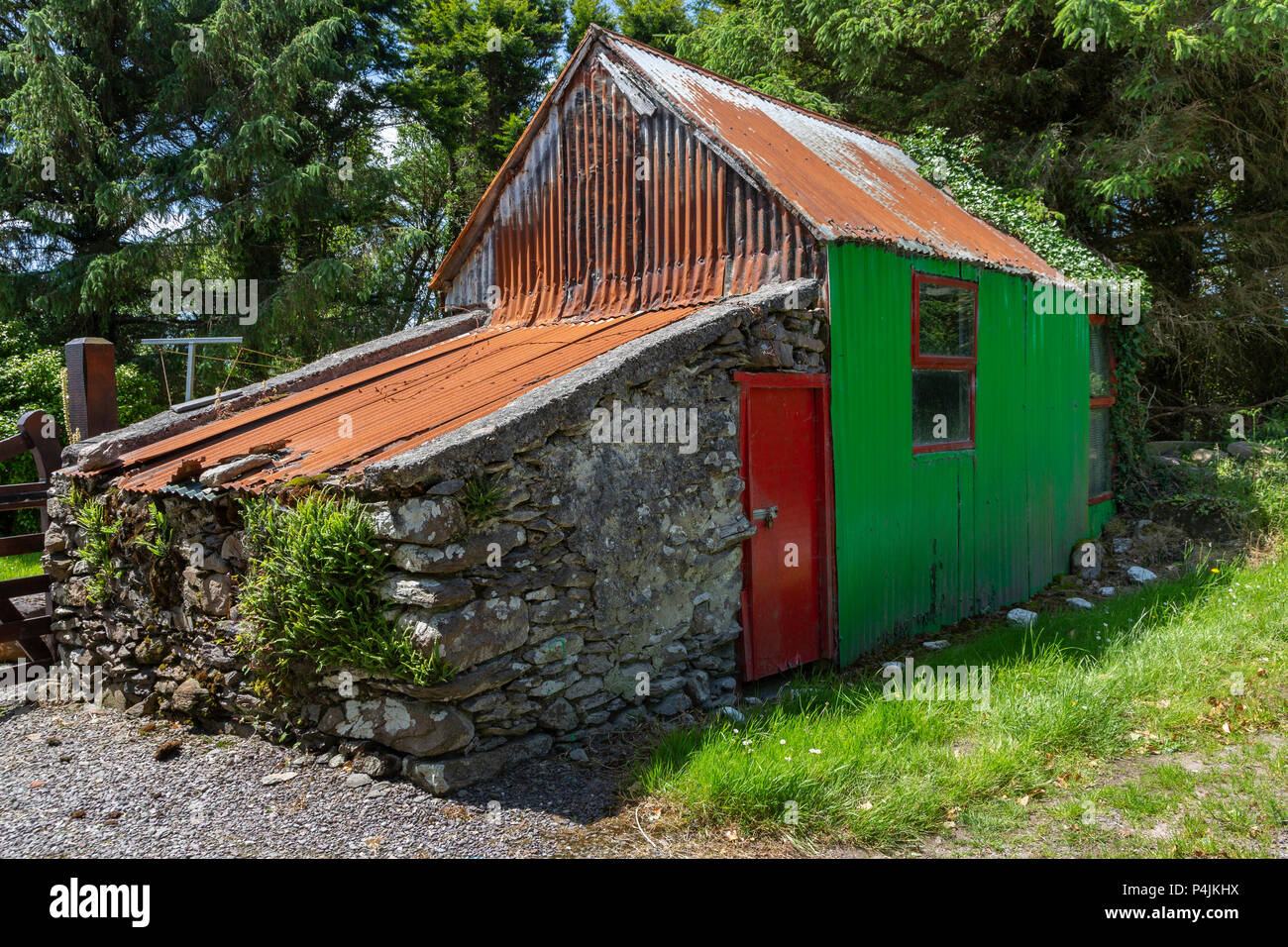 Pequeño edificio de piedra y metal corrugado en un carril del país en el condado de Kerry, Irlanda Foto de stock