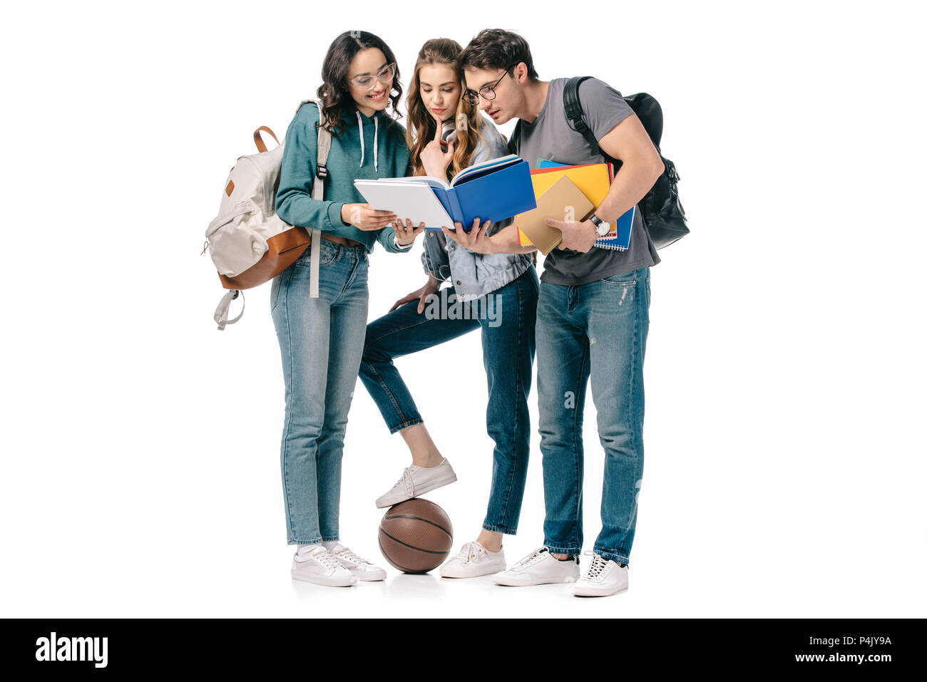 Los estudiantes multiétnica mirando libro aislado en blanco Foto de stock