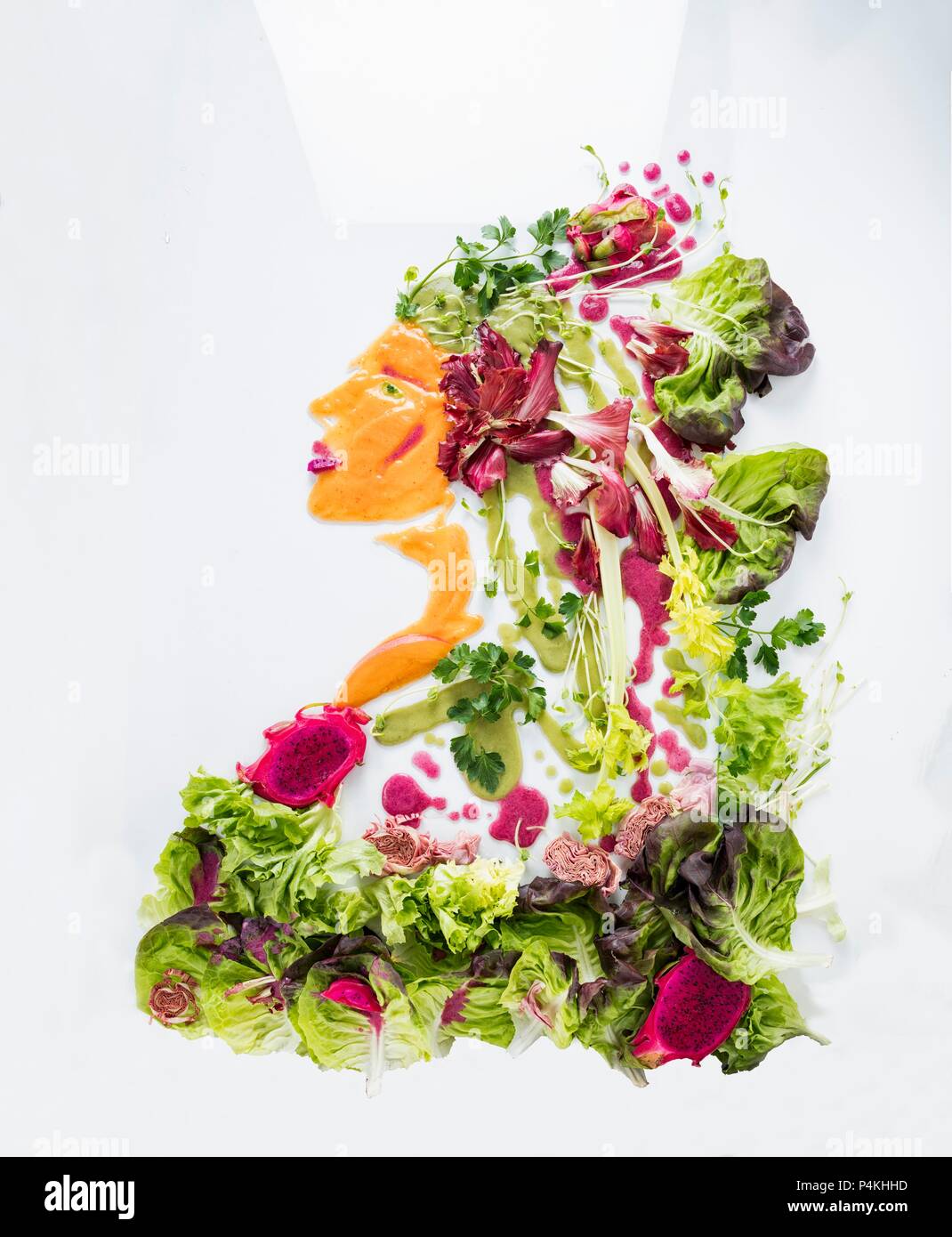 Un retrato de una mujer de la lechuga, las verduras y la fruta sobre una superficie blanca Foto de stock