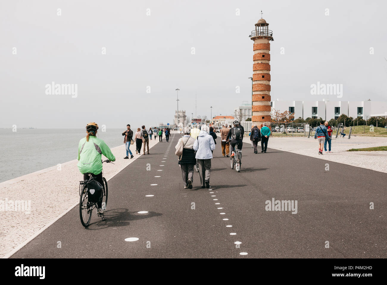 Lisboa, 18 de junio, 2018: la gente paseando por el paseo marítimo en la zona de Belem. Algunas personas ir en bicicleta. La vida en la ciudad ordinaria Foto de stock