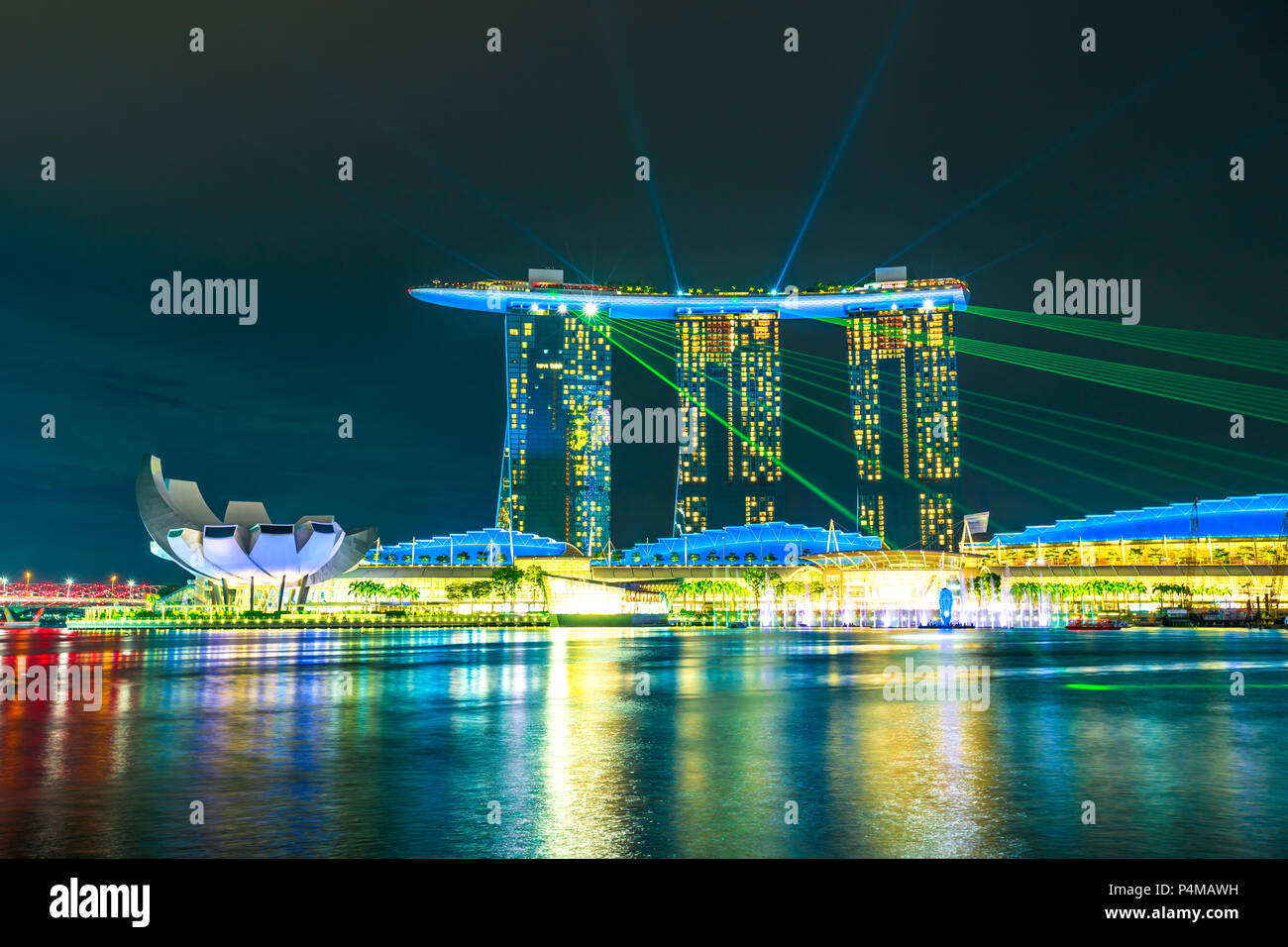 Singapur - Abril 27, 2018: icónico Marina Bay Sands con luces de colores durante el espectáculo de láser en el puerto de Singapur. La noche escenas coloridas waterfront. Atracción turística popular en la zona de Marina Bay. Foto de stock