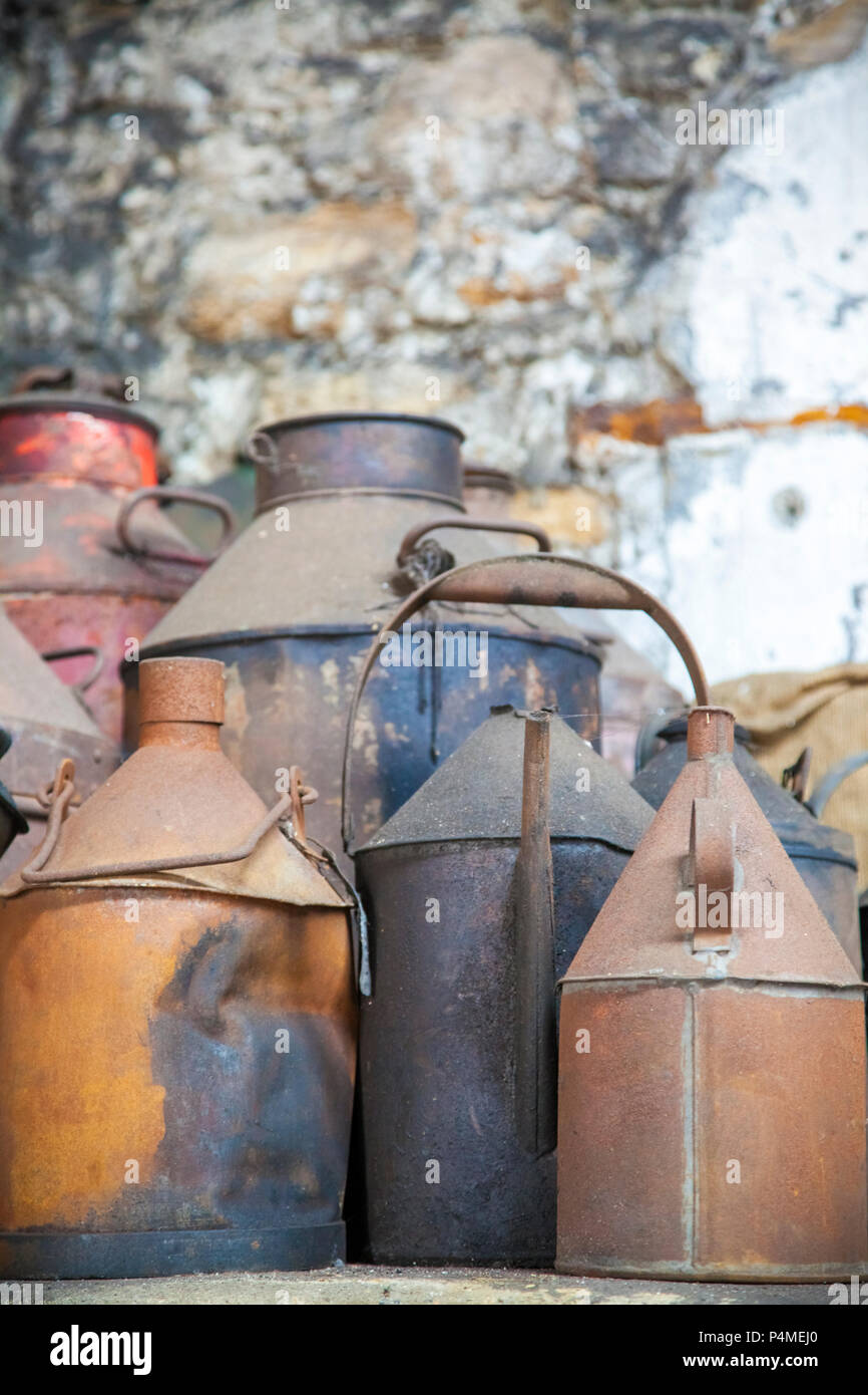 Un grupo de latas oxidadas en un antiguo taller Foto de stock