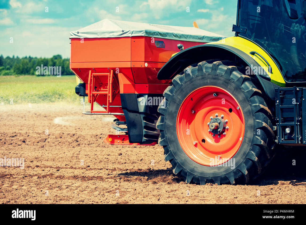 Tractor fertilizar el campo con fertilizante granular Foto de stock