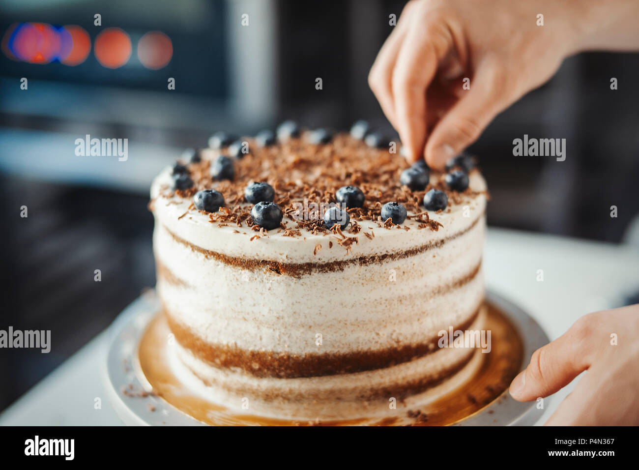 Joven Hombre atractiva decoración de torta con bayas Fotografía de stock -  Alamy