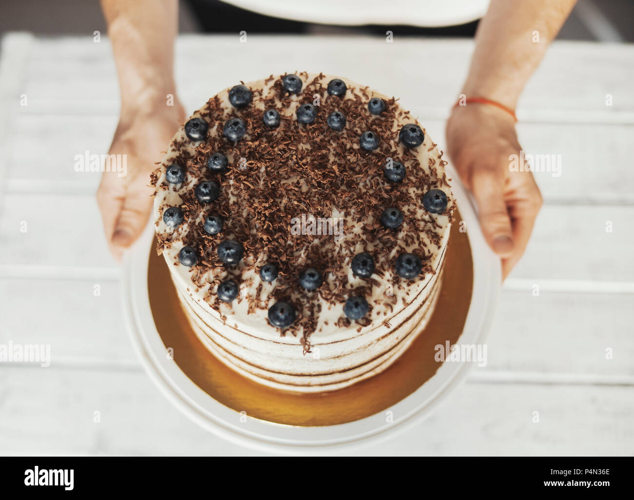 Joven Hombre atractiva decoración de pastel de chocolate y bayas Fotografía  de stock - Alamy