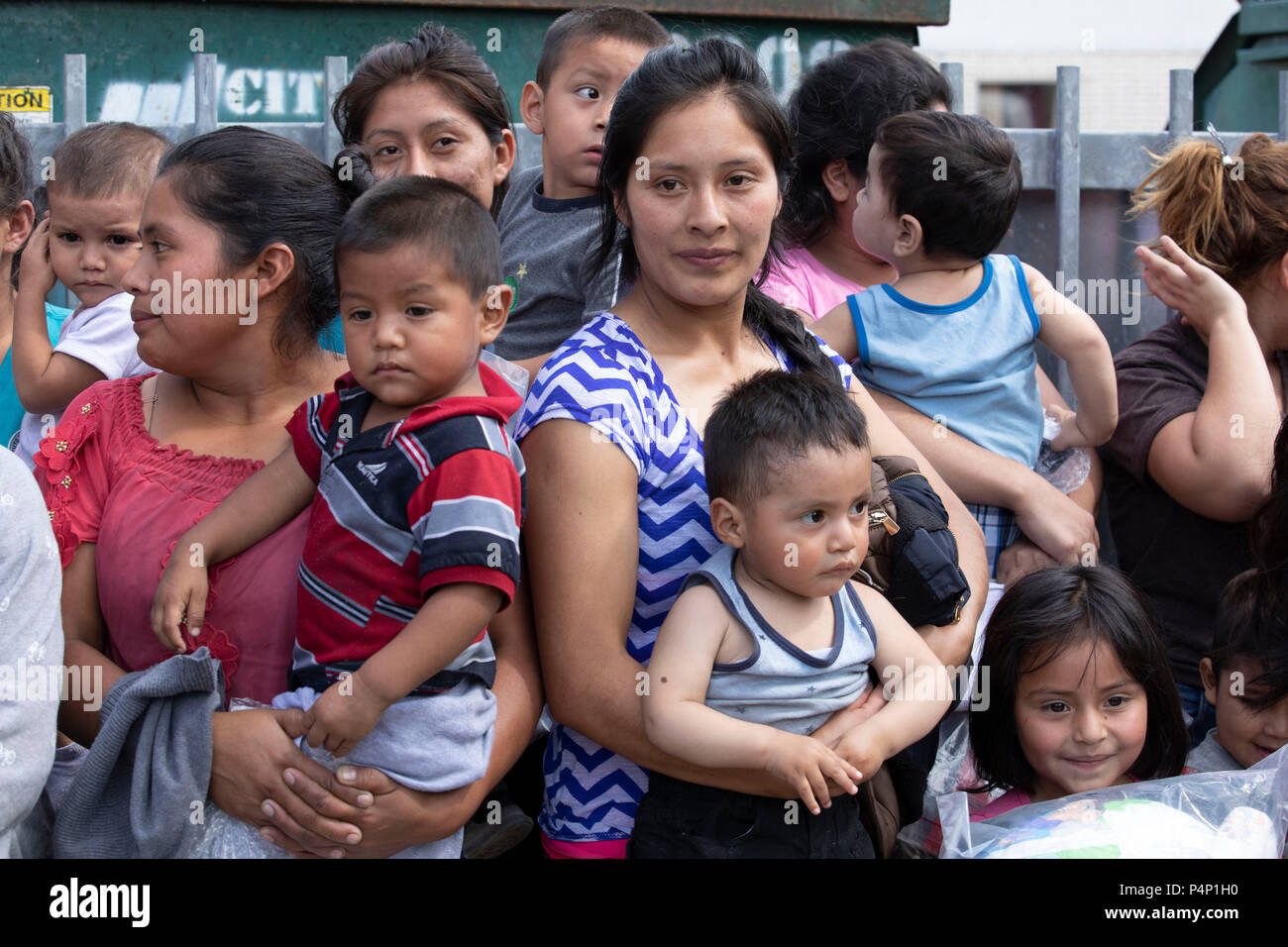 Las madres inmigrantes, vestido con dispositivos de monitoreo electrónico y sus hijos jóvenes capturados viniendo a través de la frontera con Estados Unidos en Texas son liberados en una estación de autobuses en McAllen. Las familias viajarán a quedarse con familiares en los Estados Unidos mientras esperan su deportación o solicitantes de audiencias. Foto de stock