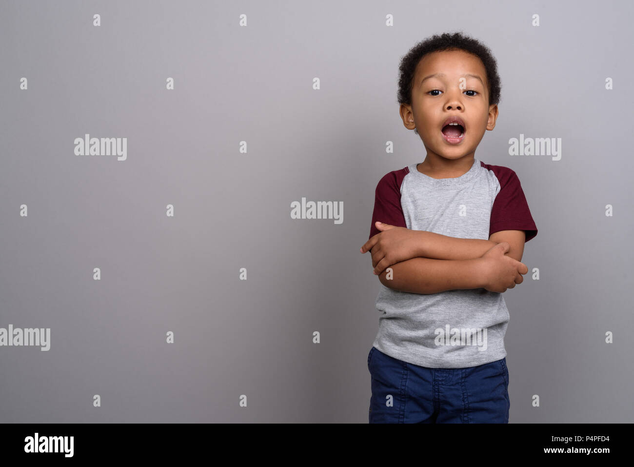 Lindo joven niño africano contra el fondo gris Foto de stock