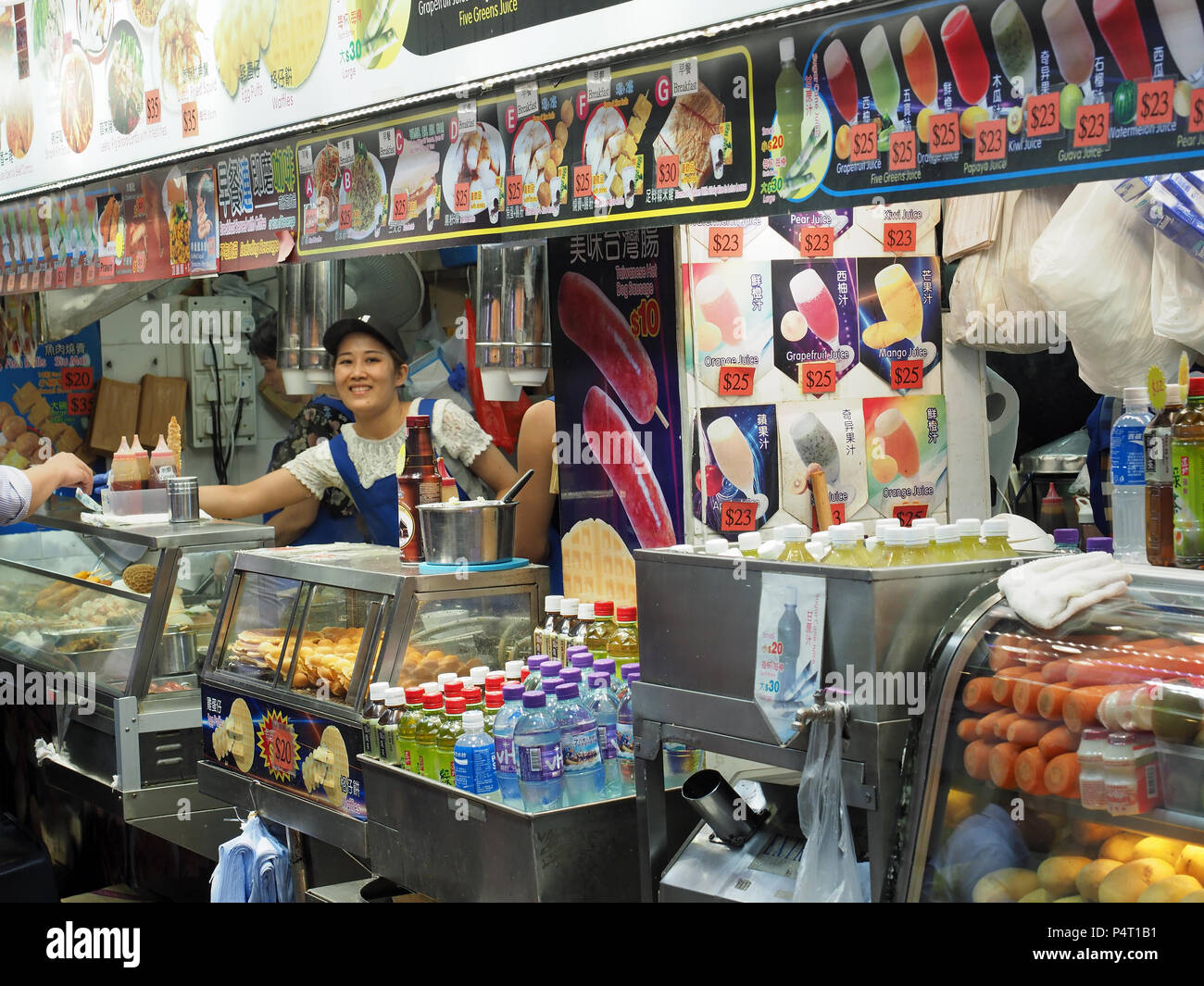 Vista de una ajetreada calle de comida rápida kiosco en Hong Kong por la noche Foto de stock
