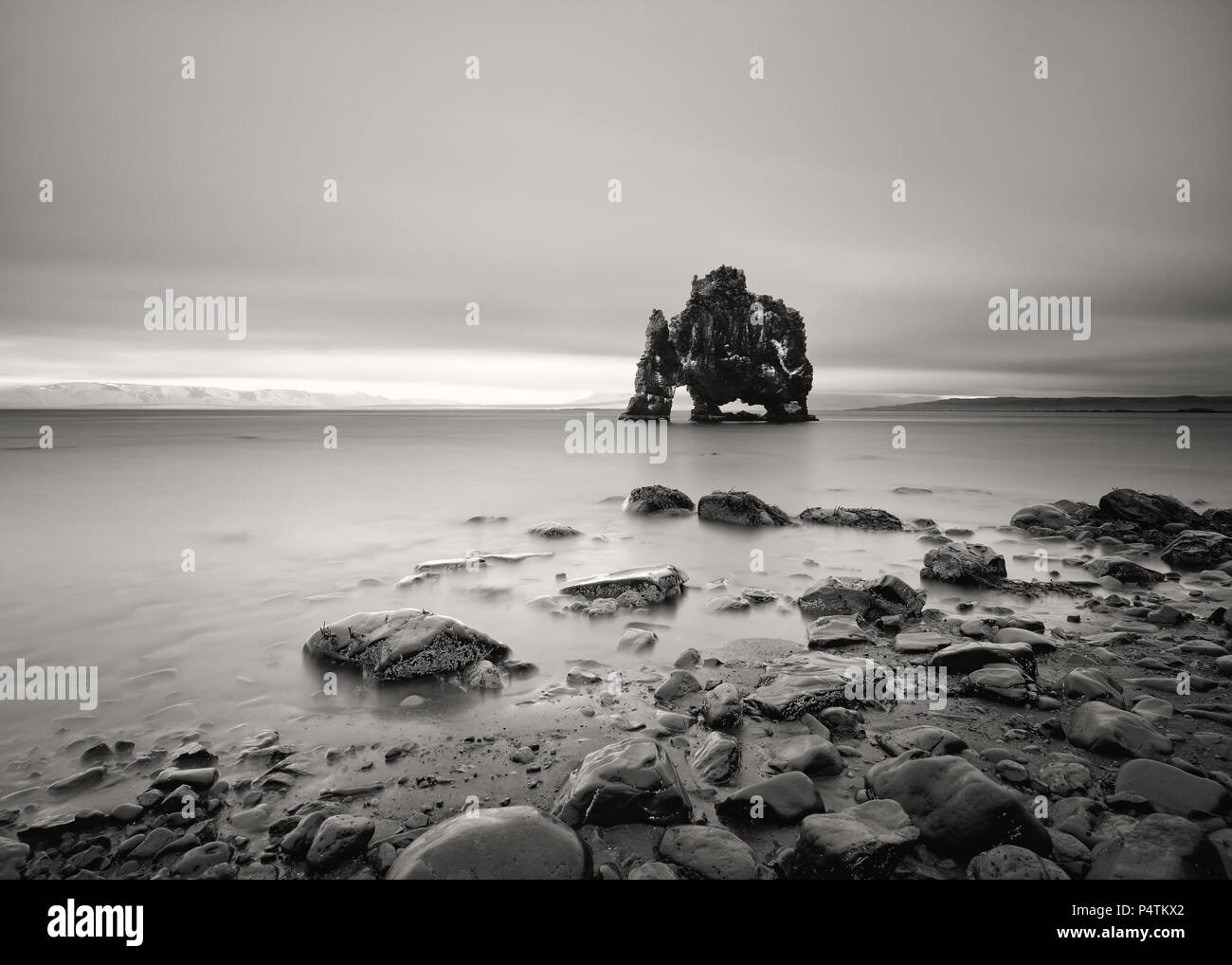Vista panorámica de una impresionante formación rocosa en aguas poco profundas en una playa con piedras - Ubicación: Islandia, en la costa oriental de la península Vatnsnes en el Nort Foto de stock