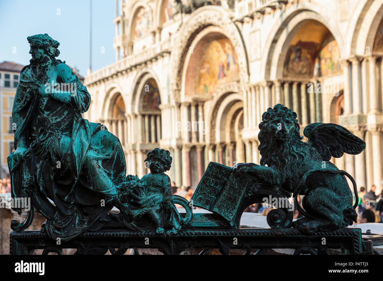 Close-up de bronces patinados en Campanile entrada con la Basílica de San Marcos, en el fondo, la Piazza San Marco, Venecia, Italia. Foto de stock