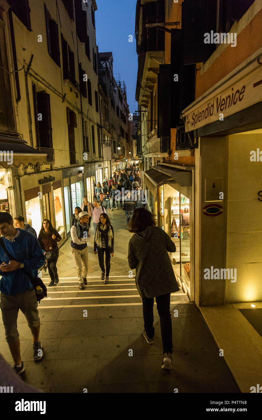 Noche multitud de turistas pasear e ir de compras por escaparate resplandor, Venecia, Italia. Foto de stock