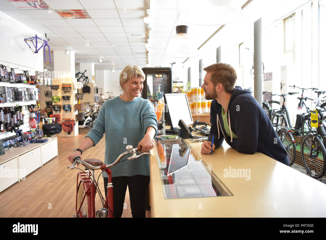 Vendedor ayudando al cliente en la tienda de bicicletas Foto de stock