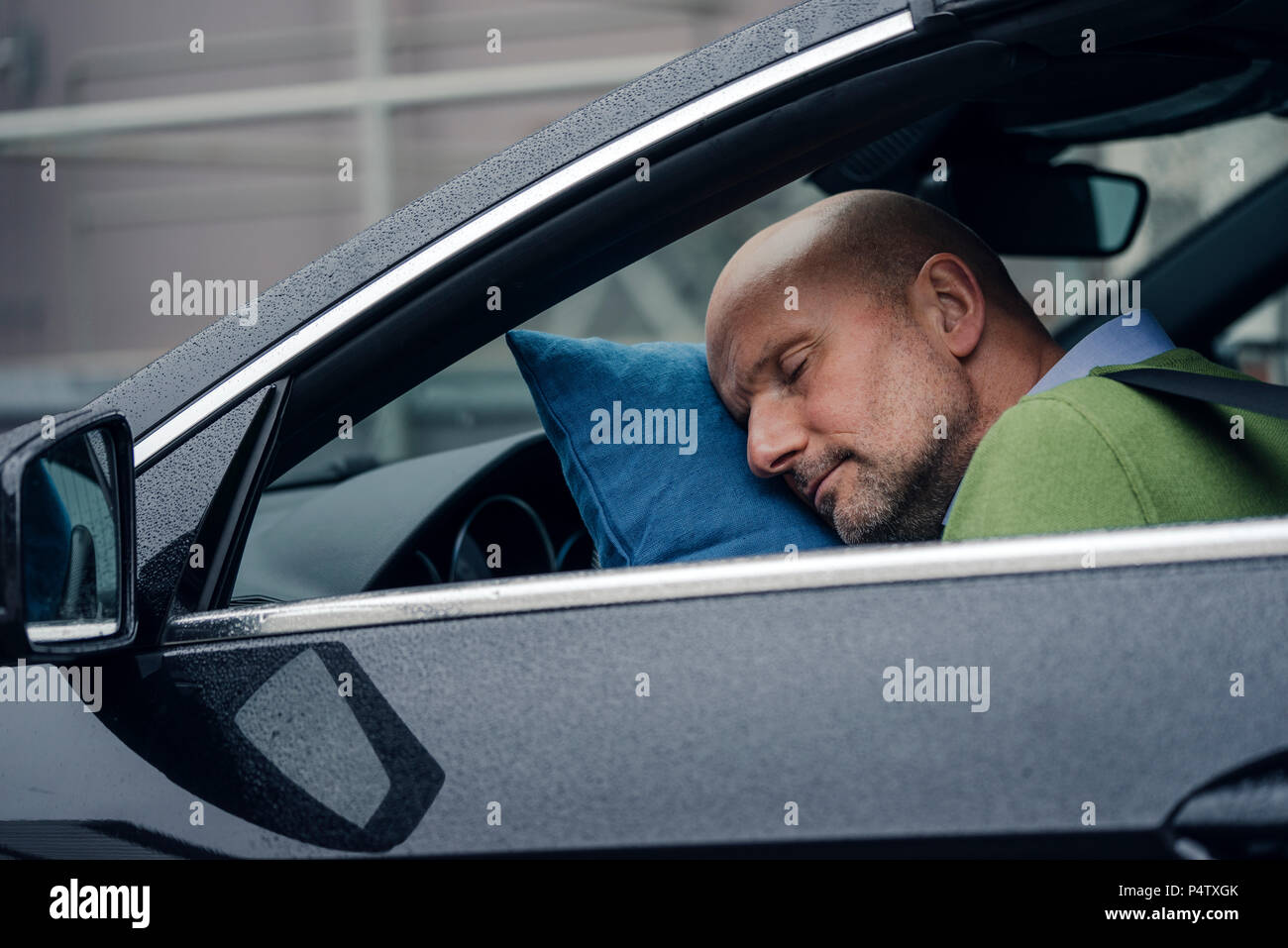 Hombre maduro, durmiendo en el coche Foto de stock