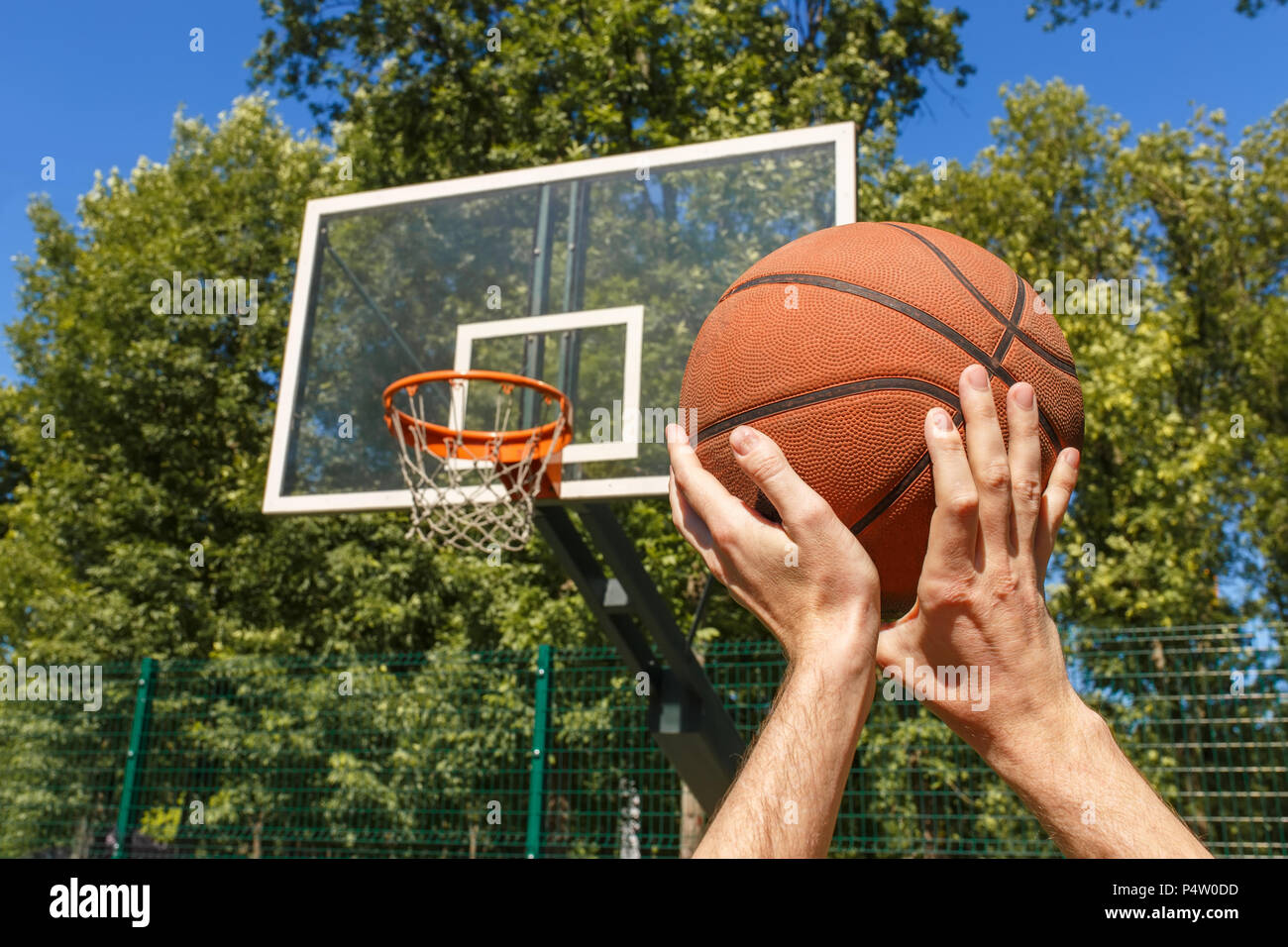 Manos lanzando pelota de baloncesto Foto de stock