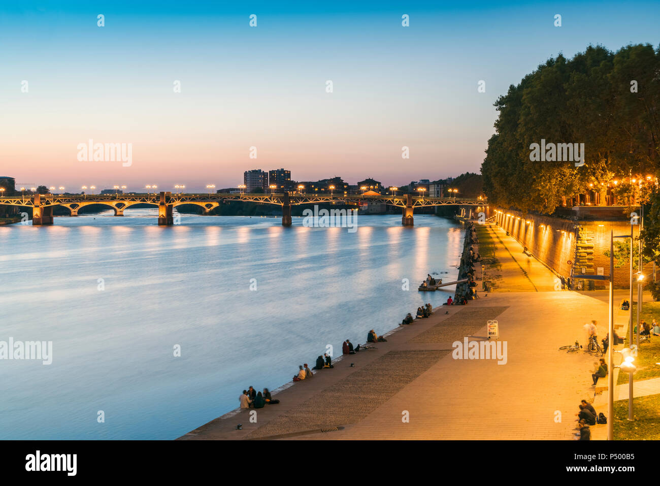 Francia, Toulouse, Haute-Garonne, Río Garona con Pont Saint Pierre y paseo en la luz de la tarde Foto de stock