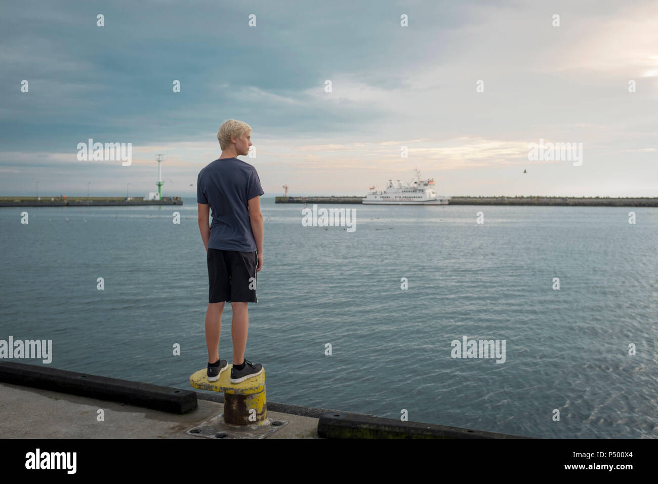 Polonia, la Bahía de Gdansk, adolescente de pie sobre el malecгіn mirando a distancia Foto de stock