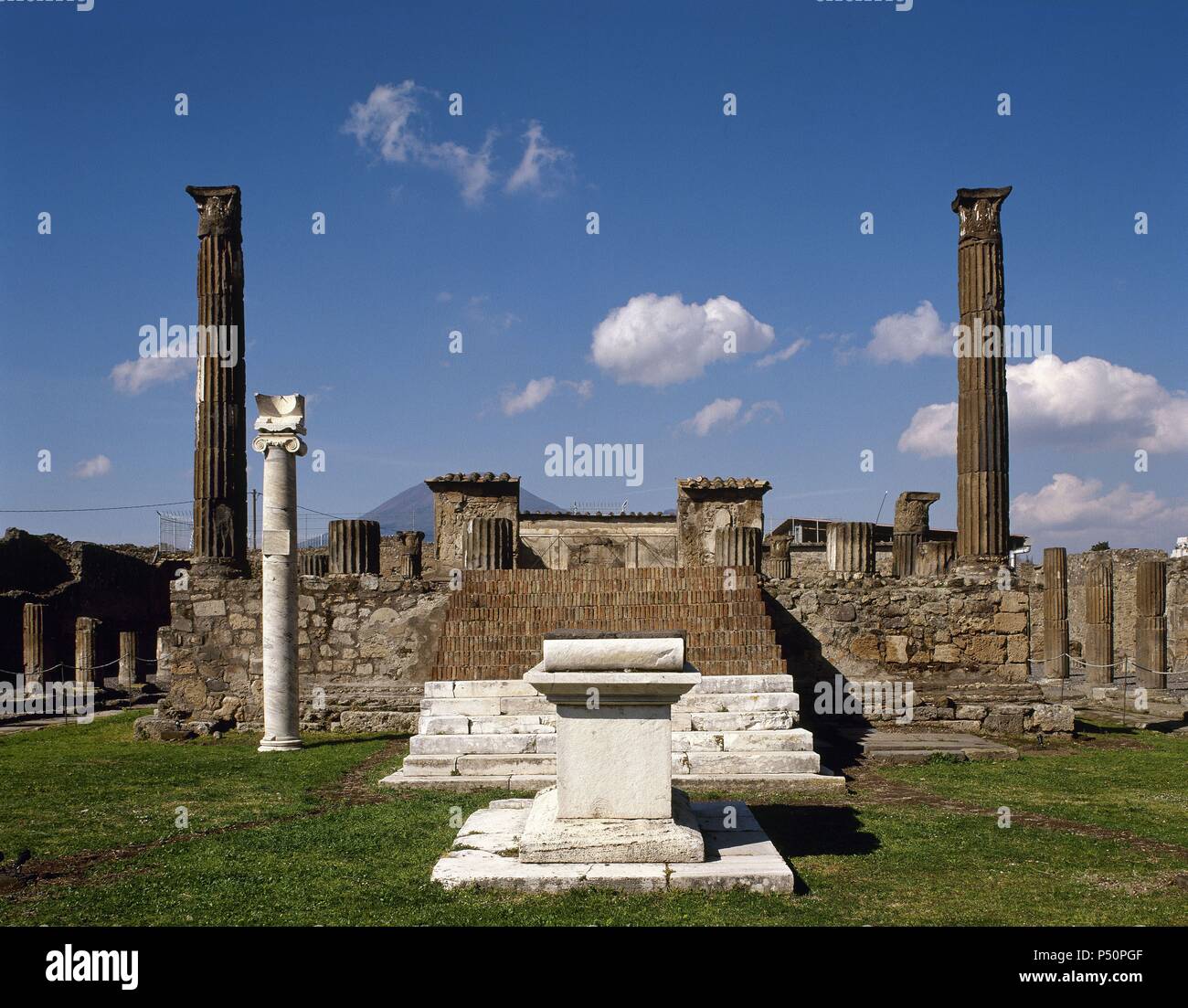 Italia. Pompeya. Templo de Apolo. El altar de mármol y columnas jónicas fue construida para albergar el reloj de sol. En el fondo. las escaleras y dos columnas corintias acanaladas. Foto de stock