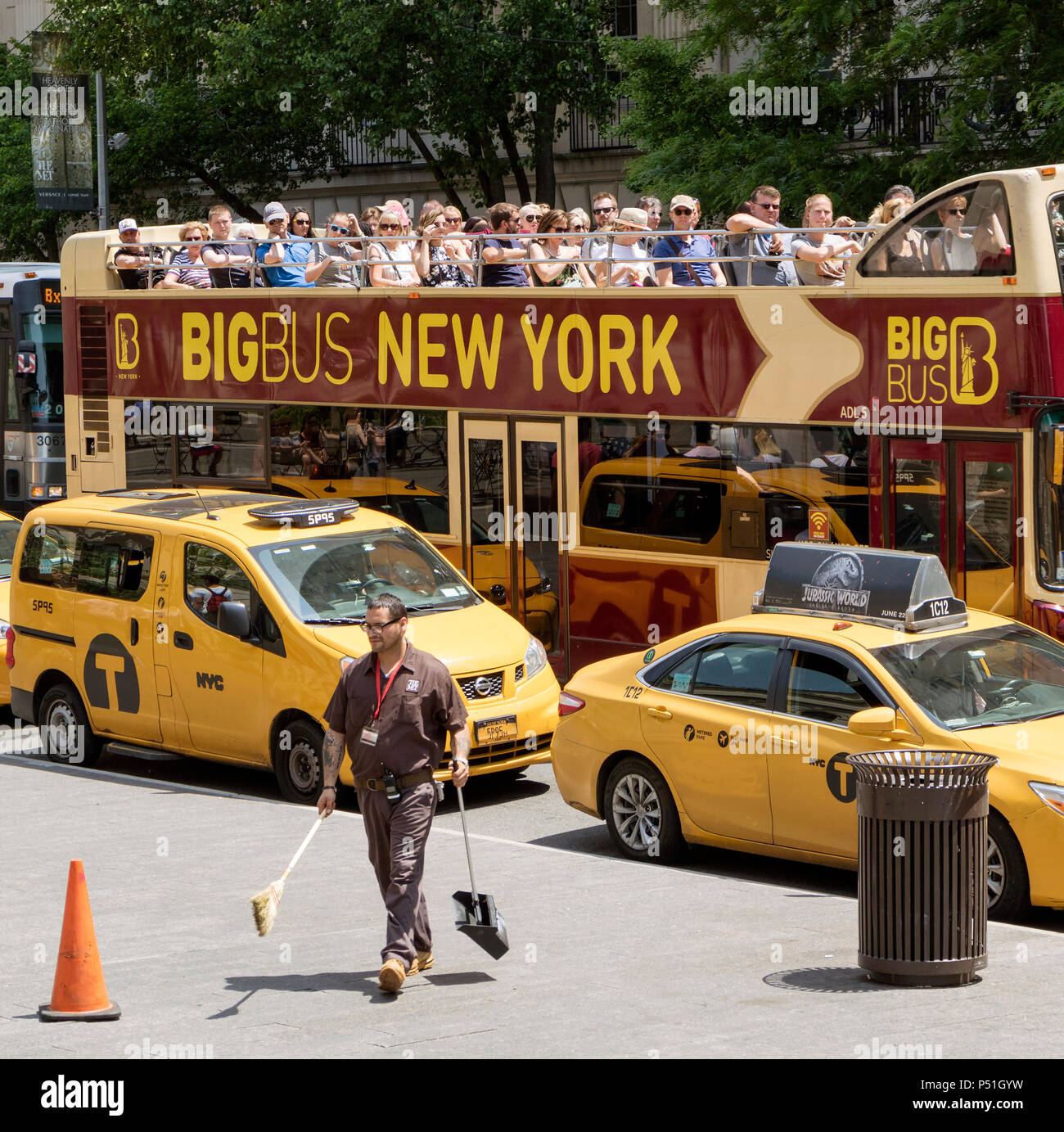 Nueva York, EE.UU. El hombre uniformado de la reunió con pala para recoger basura y cepillo de limpieza en la acera fuera de este famoso museo Miró autobús cargado de turistas. Foto de stock