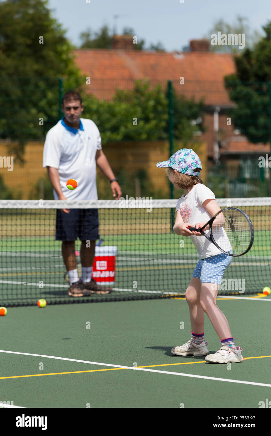 Sesión de entrenamiento de tenis para niños / lección teniendo lugar sobre  una pista de tenis de tamaño completo con niños / Niños y Entrenador de  tenis profesional, en verano. En el