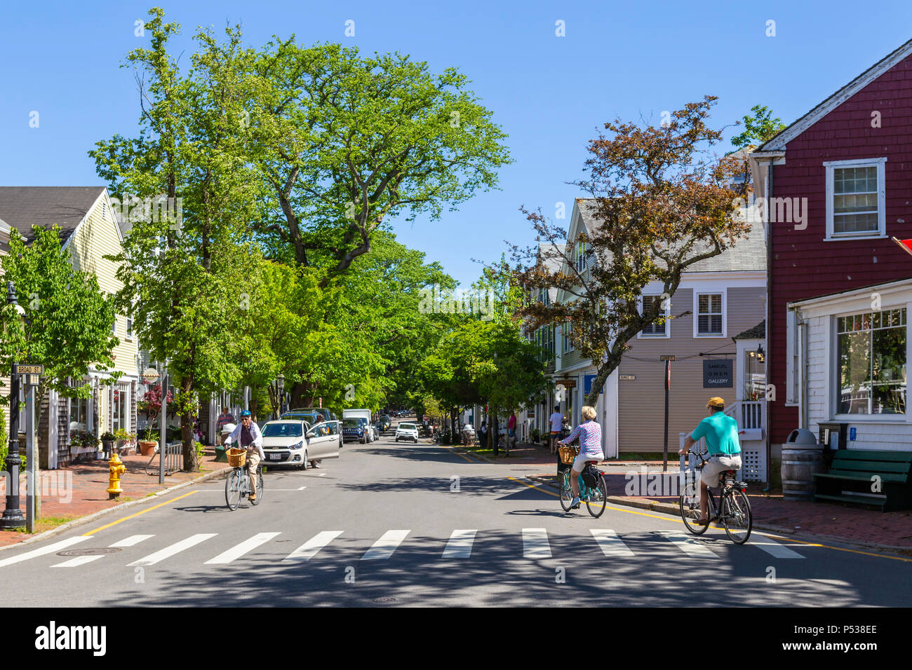 Los ciclistas paseo en Broad Street en Nantucket, Massachusetts. Foto de stock