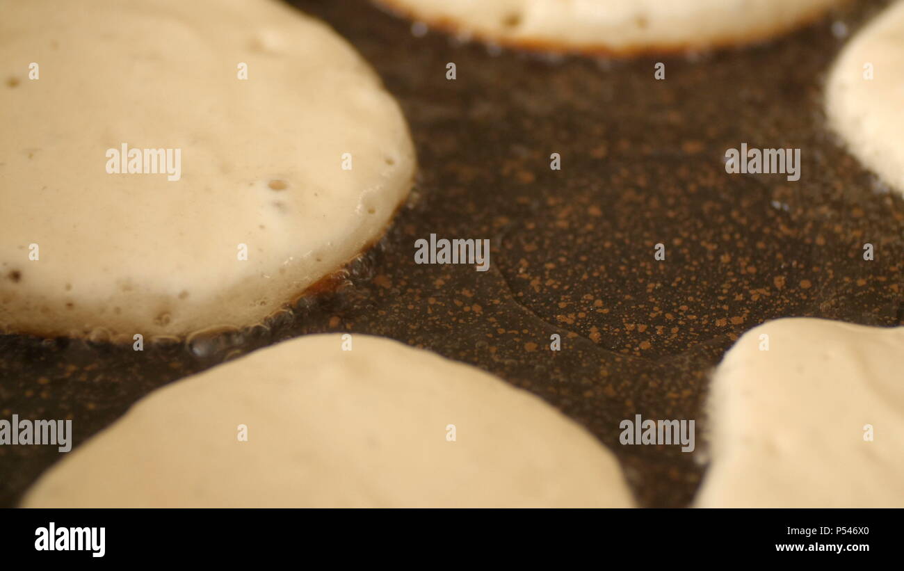 Acercamiento blanco fresco pancake masa fritos en aceite vegetal en la  burbuja de hierro fundido de precalentamiento pan en casa Fotografía de  stock - Alamy