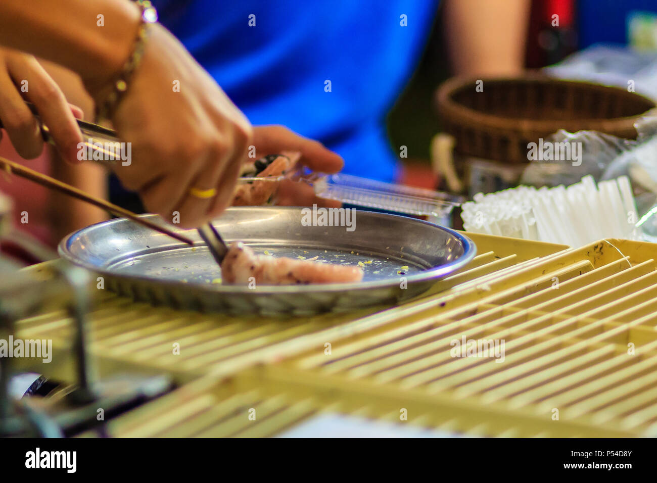 Cerrar la mano del vendedor durante la cocción para Tootsie Roll crujiente o aperitivo tailandés, Thai postre comida estilo tailandés llamado 'Thong' o 'muan Tong Muan', un tipo Foto de stock