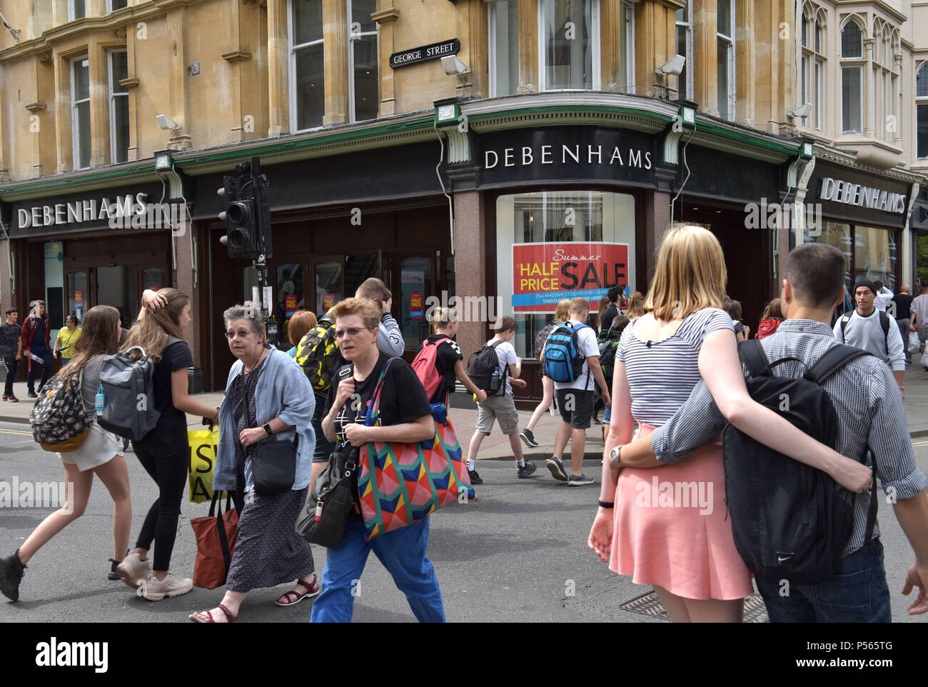 Los compradores y los turistas camina más allá de los almacenes Debenhams en la esquina de la calle High Street, George Street en Oxford Foto de stock