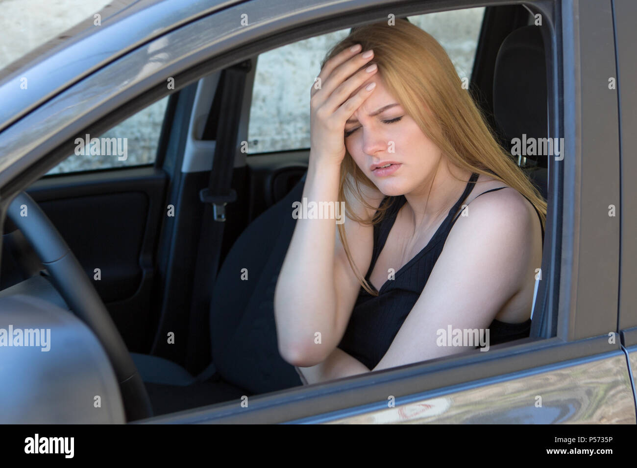 Mujer en el dolor en coche Foto de stock