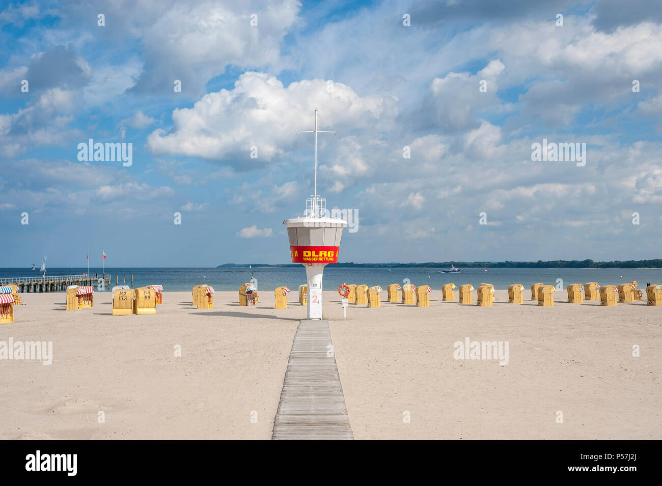 Playa vacía con torre de vigilancia DLRG y sillas de playa, Travemünde, Mar Báltico, Schleswig-Holstein, Alemania Foto de stock