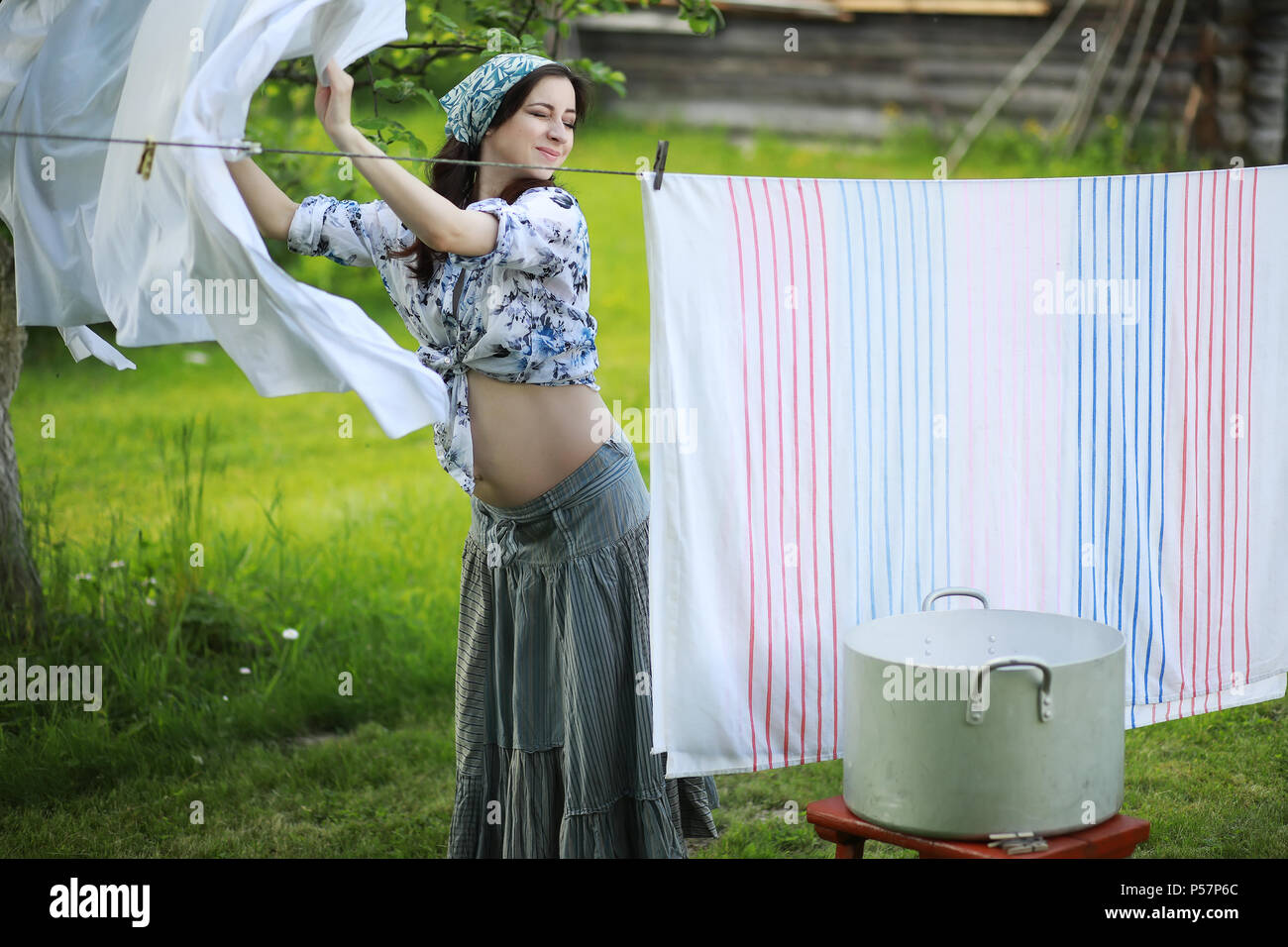 Mujer embarazada colgando a lavar su ropa en la cuerda para secar en la  naturaleza Fotografía de stock - Alamy