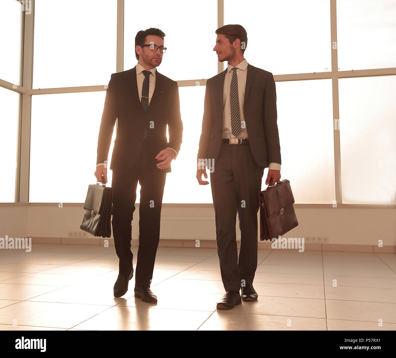 Imagen de fondo. Dos hombres de negocios de pie en el vestíbulo de la oficina Foto de stock