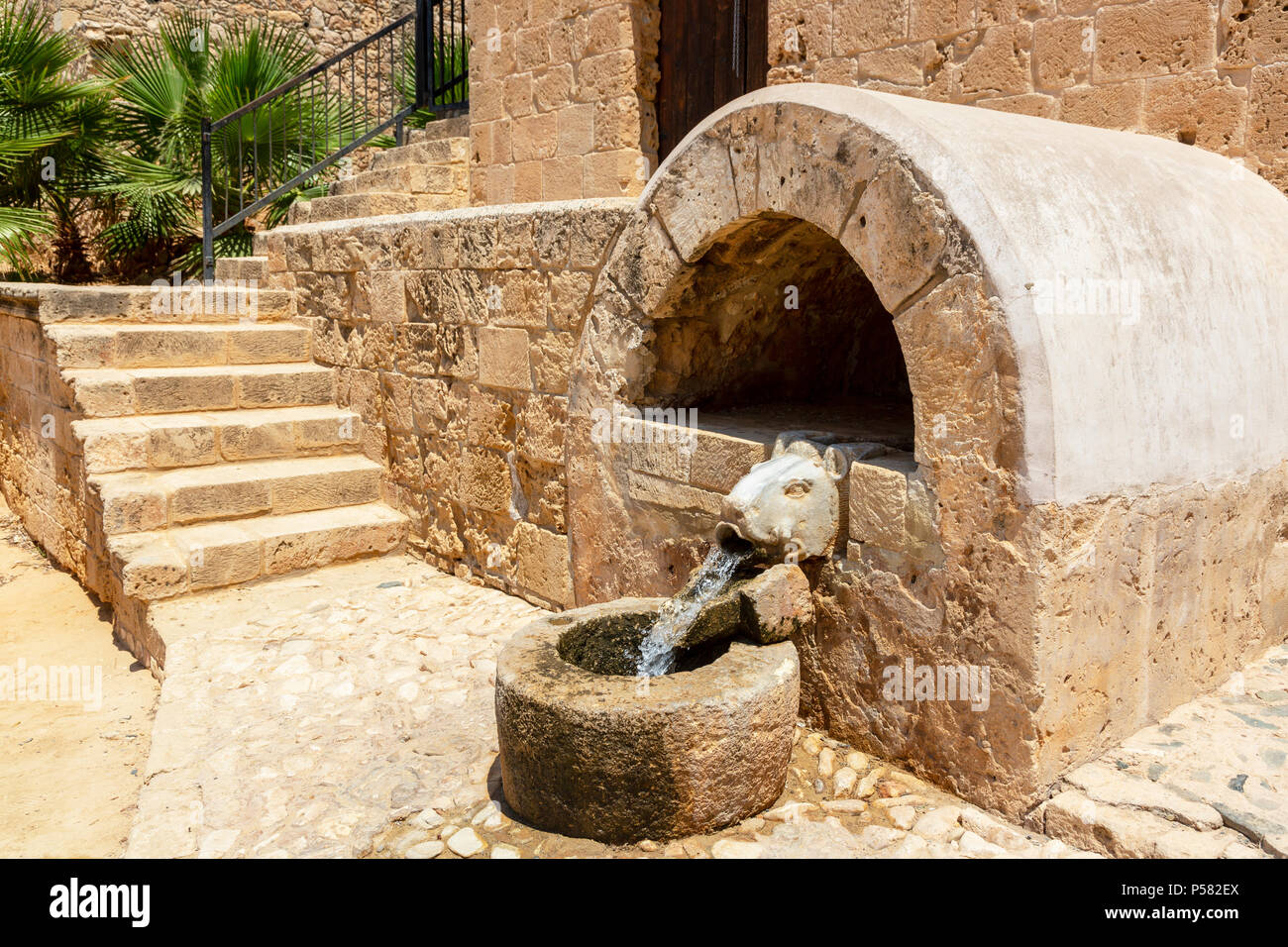Un pozo de agua fresca que se ejecutan a través de un jabalí estatua en un pilón de piedra, Agia Napa, Ayia Napa Monasterio, Ayia Napa, Chipre Foto de stock