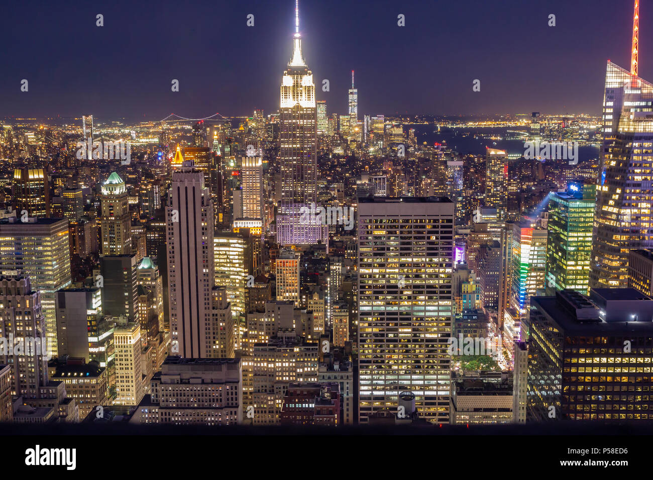 La Ciudad de Nueva York en la noche, visto desde la cima de la roca. El Empire State Building en el centro del bastidor, torre de la libertad en la distancia. Foto de stock